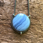 Load image into Gallery viewer, Strikingly good quality circular Blue Lace Agate Pendant with oxidized sterling silver chain on driftwood background
