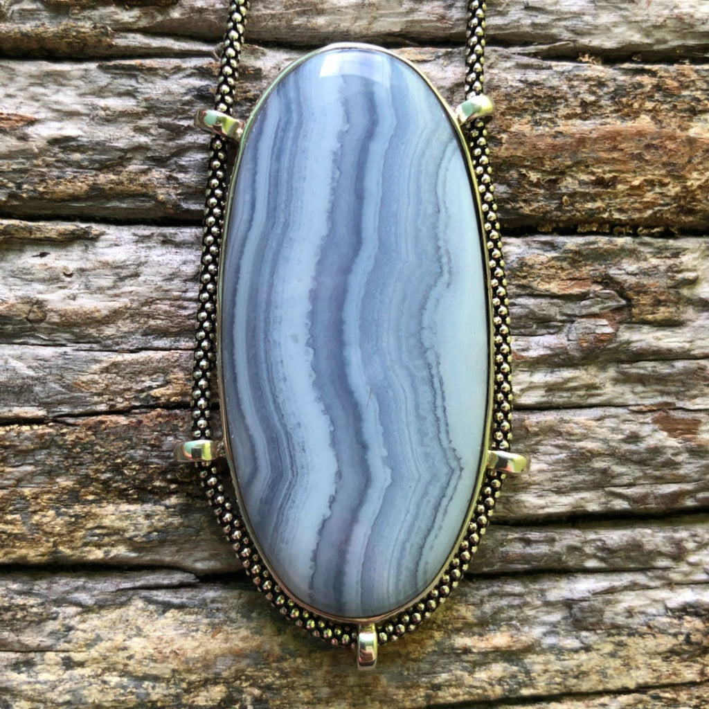 blue stripey Blue Lace Agate Pendant on driftwood background