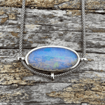 Load image into Gallery viewer, blue opal pendant set in sterling silver smooth oval shape on a piece of driftwood
