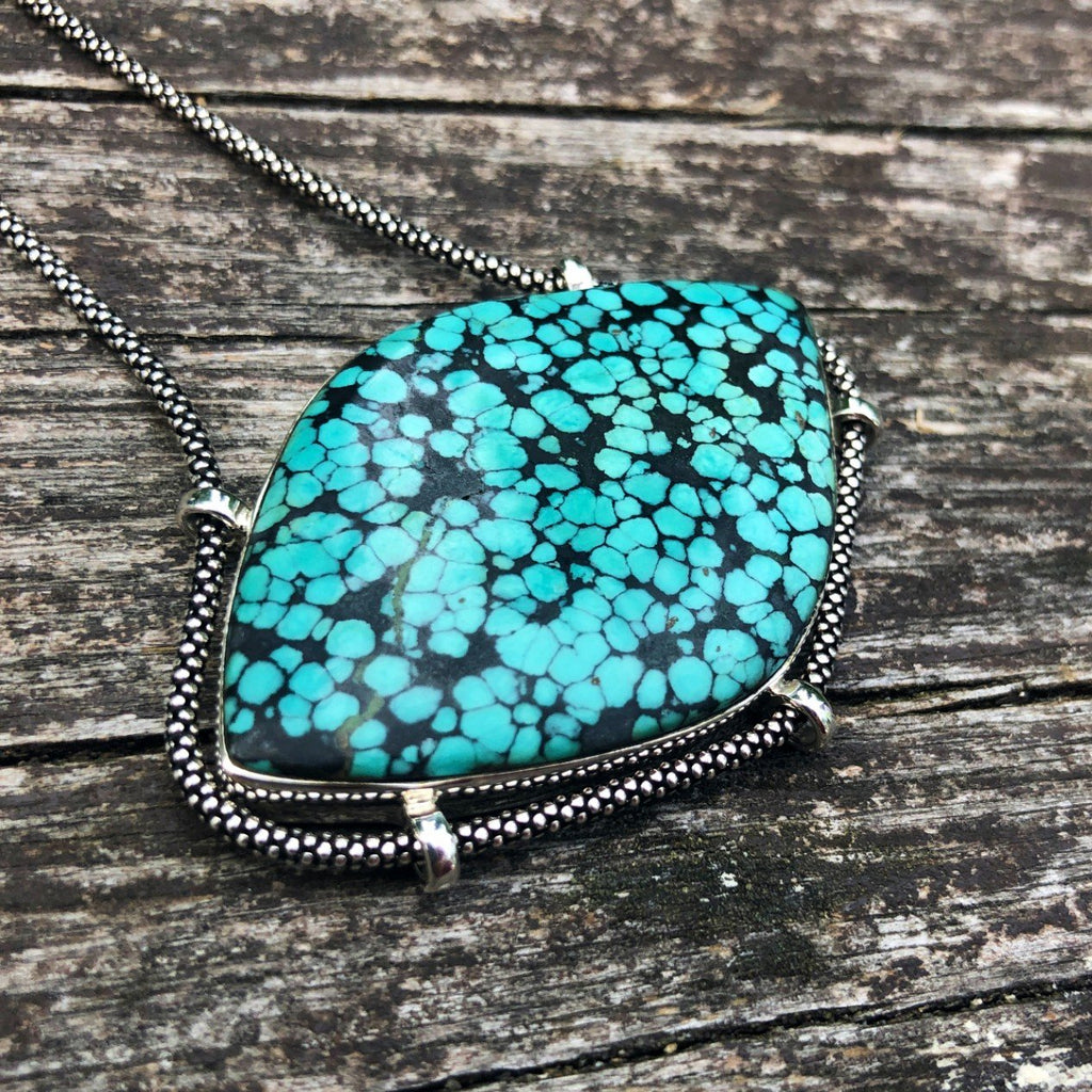 authentic turquoise horizontal shaped pendant on unique setting weathered driftwood background. ozidized sterlihg silver chain