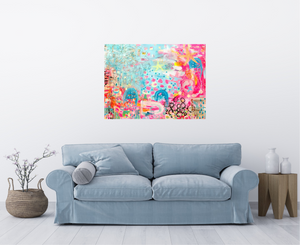 vibrant, happy abstract painting with pinks and blues and stars and hearts and an ocean vibe over a soft grey couch in an airy white room